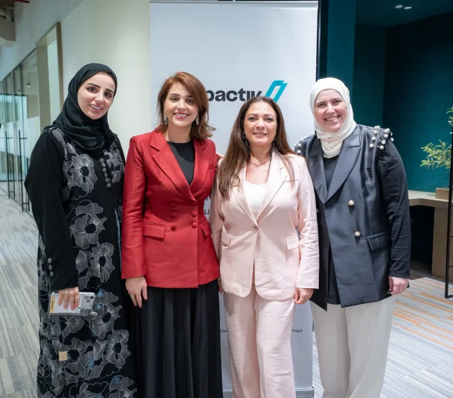 The Impactiv team in front of the Impactiv banner at a programme event