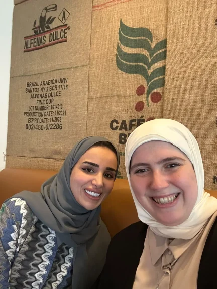 Two Impactiv team members smiling together at a café meeting